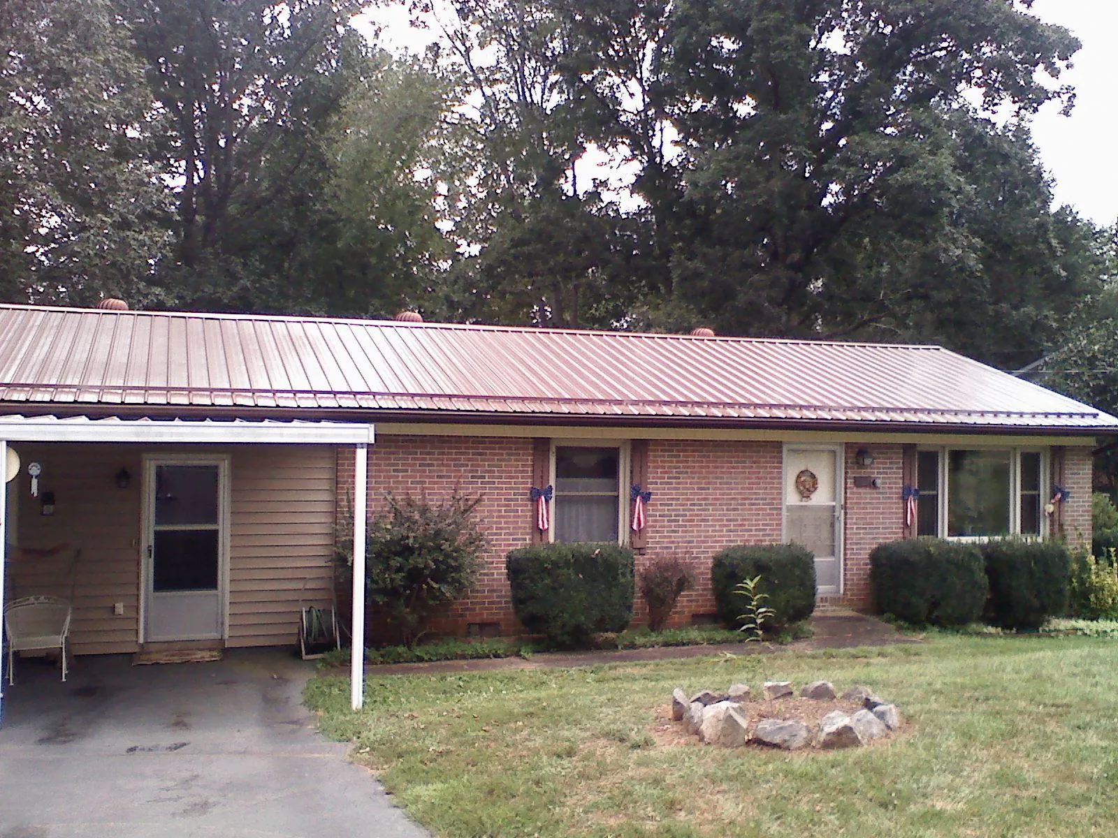 Bronze metal roof and carport on a brick ranch home — Roof Repair work by our crew in Flowood