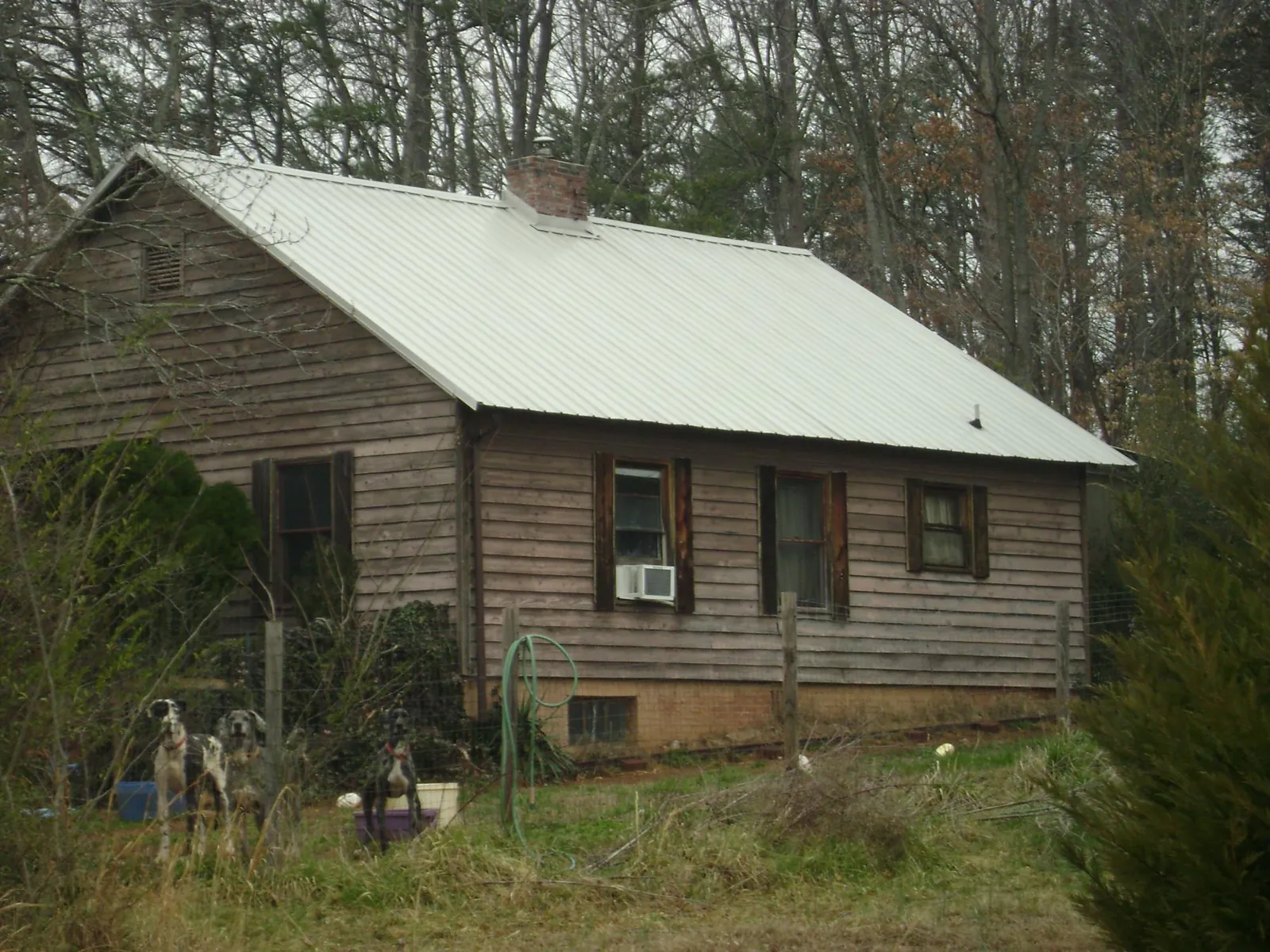 White metal roof on an old wood sided farmhouse, from a Asphalt Shingle Roof Repair job in Flowood